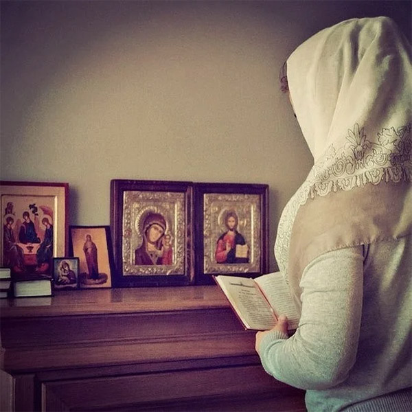 Молится дома перед иконами