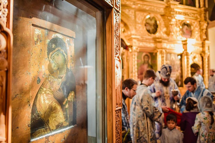 Священник причащает в храме