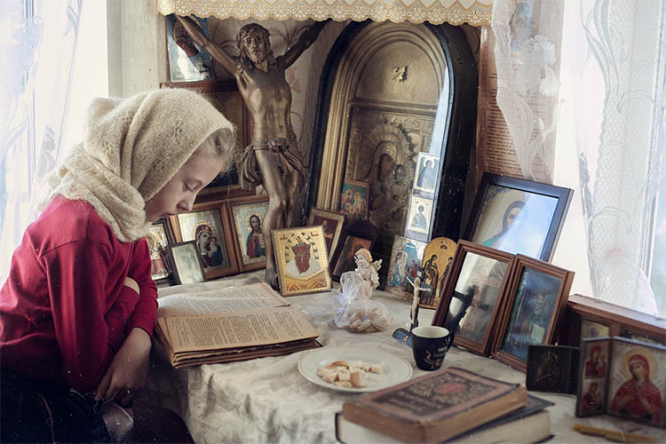 Девочка читает перед иконами