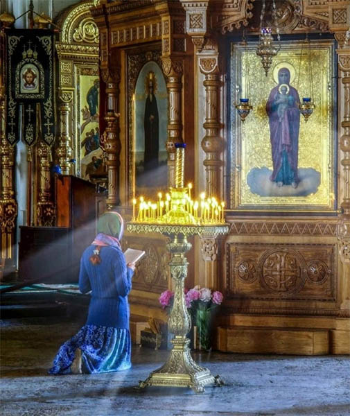 Женщина молится в храме
