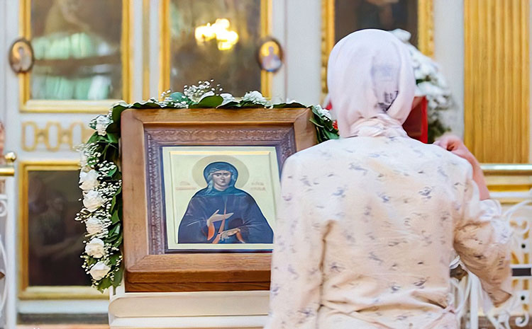 Женщина перед образом блаженной Ксении Петербургской