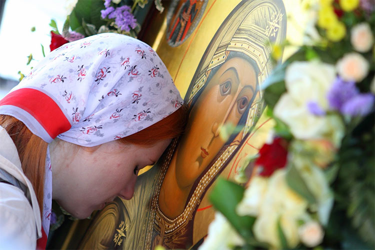 Женщина перед иконой Богородицы