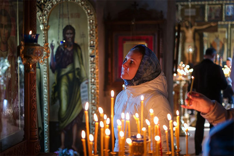 Женщина перед иконой в храме