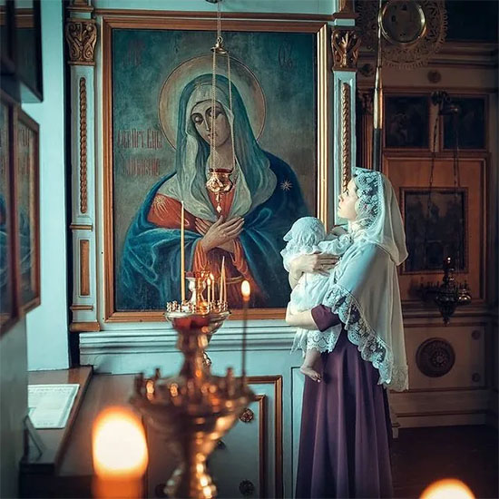 Женщина с младенцем перед иконой Богородицы