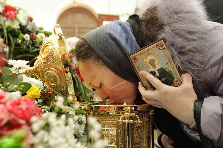 Женщина у ковчега с мощами блаженной матушки Матроны