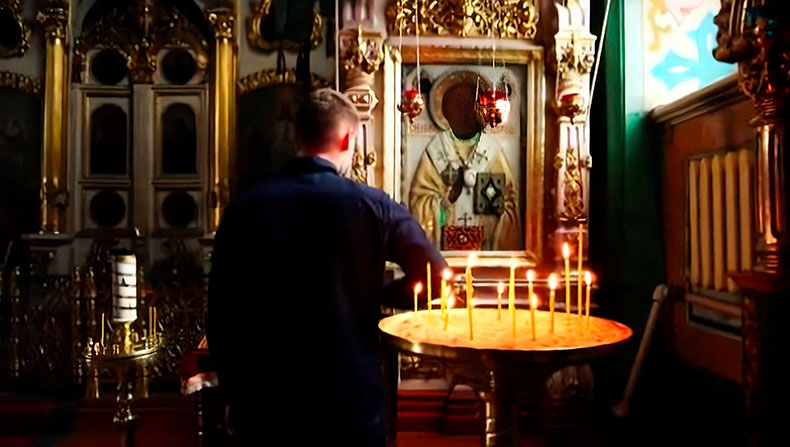 Мужчина перед образом Николая Чудотворца в храме