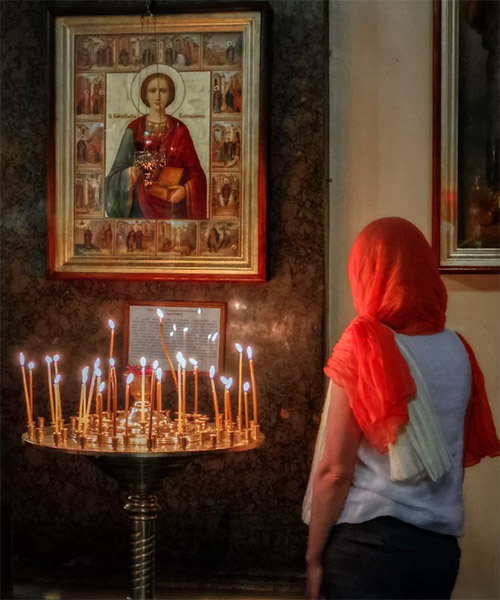 Женщина перед иконой великомученика Пантелеймона