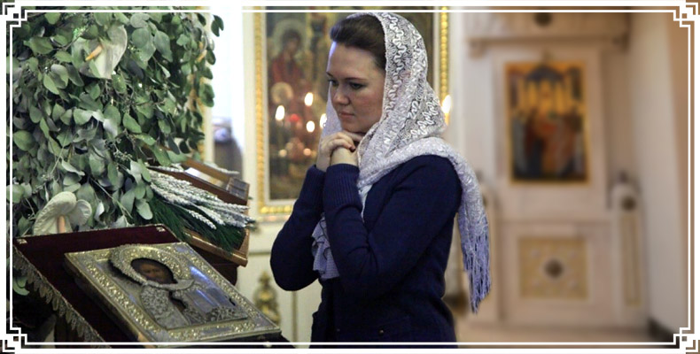 Женщина молится в храме